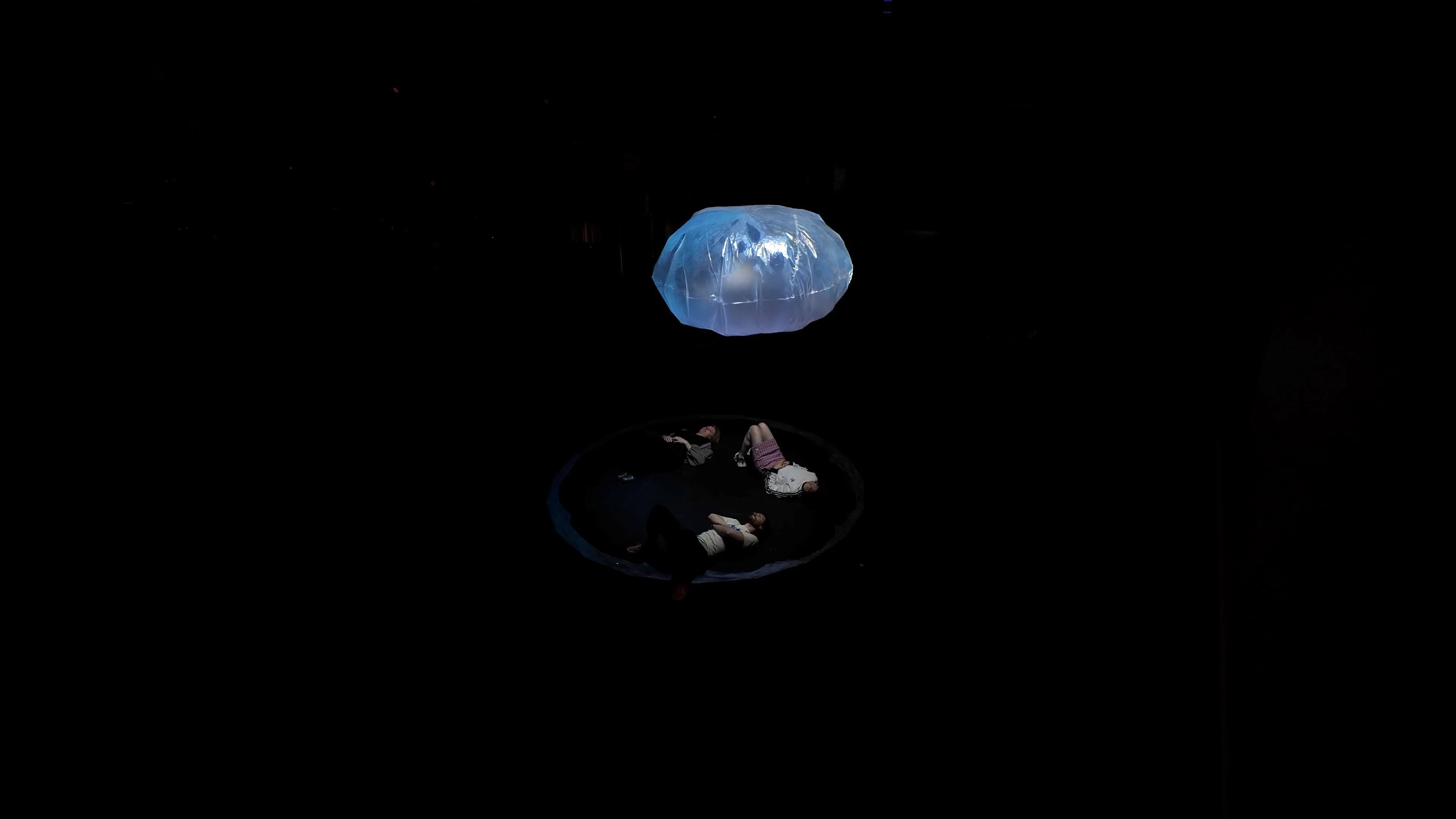 Visitors lying on the floor beneath A Bubble